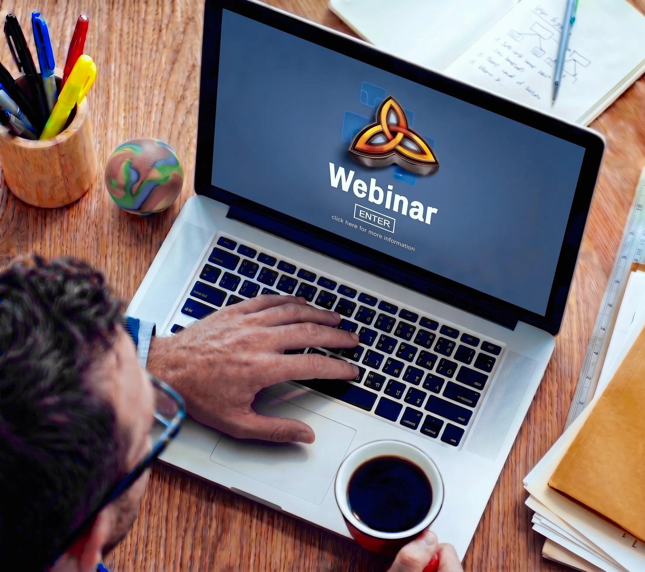 A laptop on a desk showing the TriTechnologies webinar welcome screen